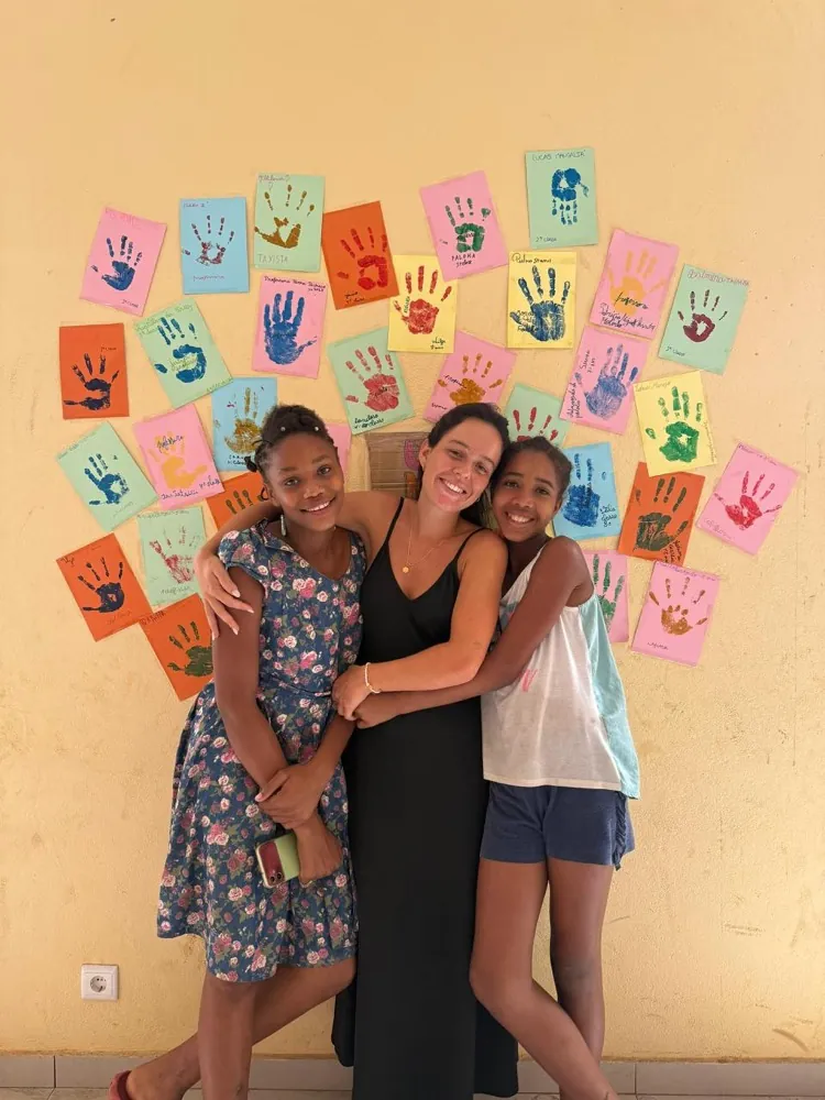 Rita Lúcio, voluntária da Associação BAOBÁ, com duas crianças em São Tomé e Príncipe